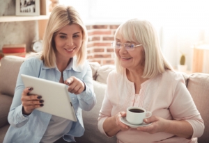 caregiver and senior using tablet